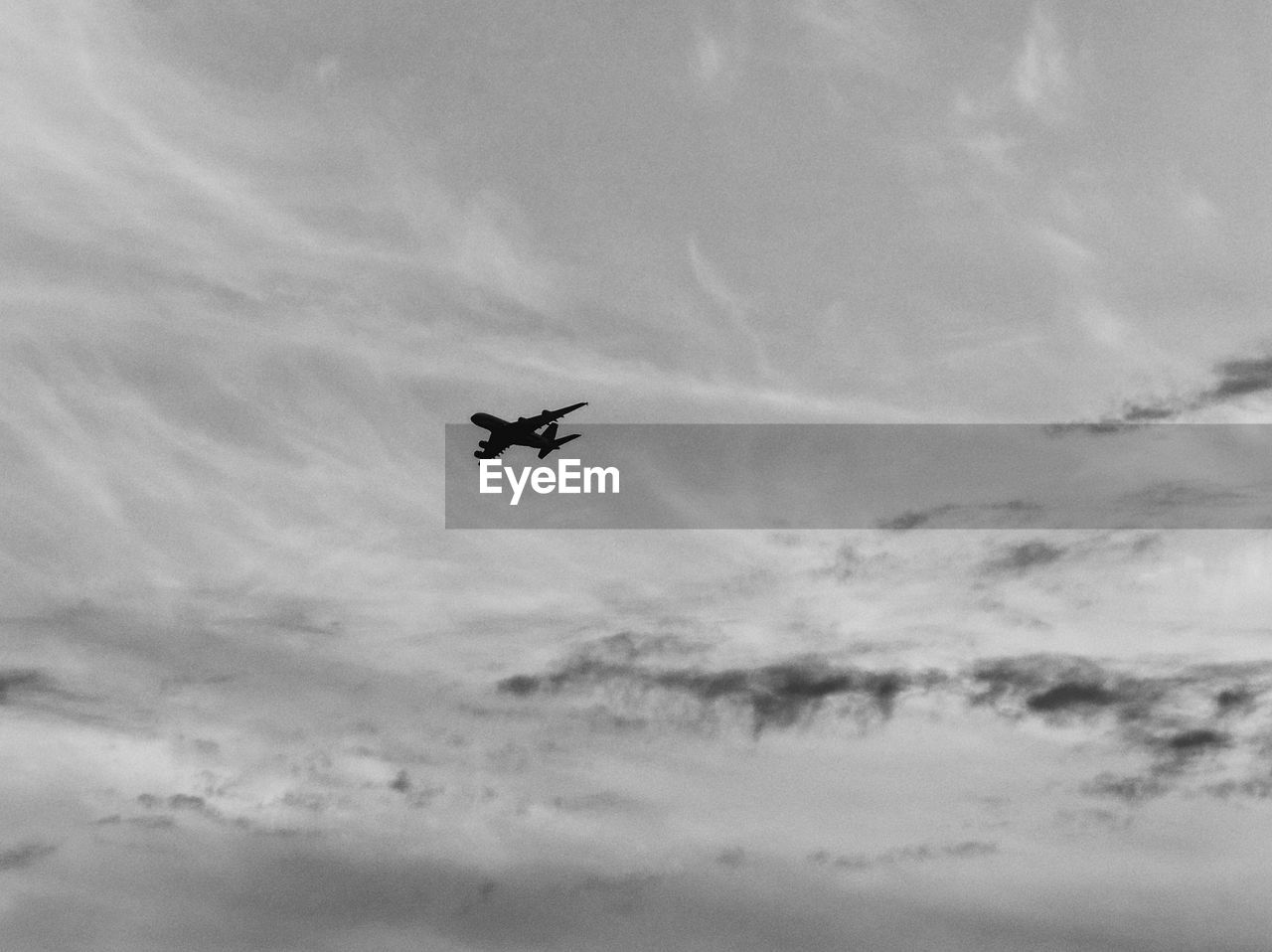 CLOSE-UP OF AIRPLANE FLYING AGAINST SKY
