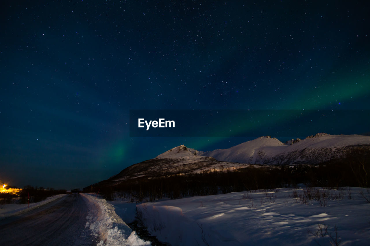 Scenic view of snowcapped mountains against sky at night