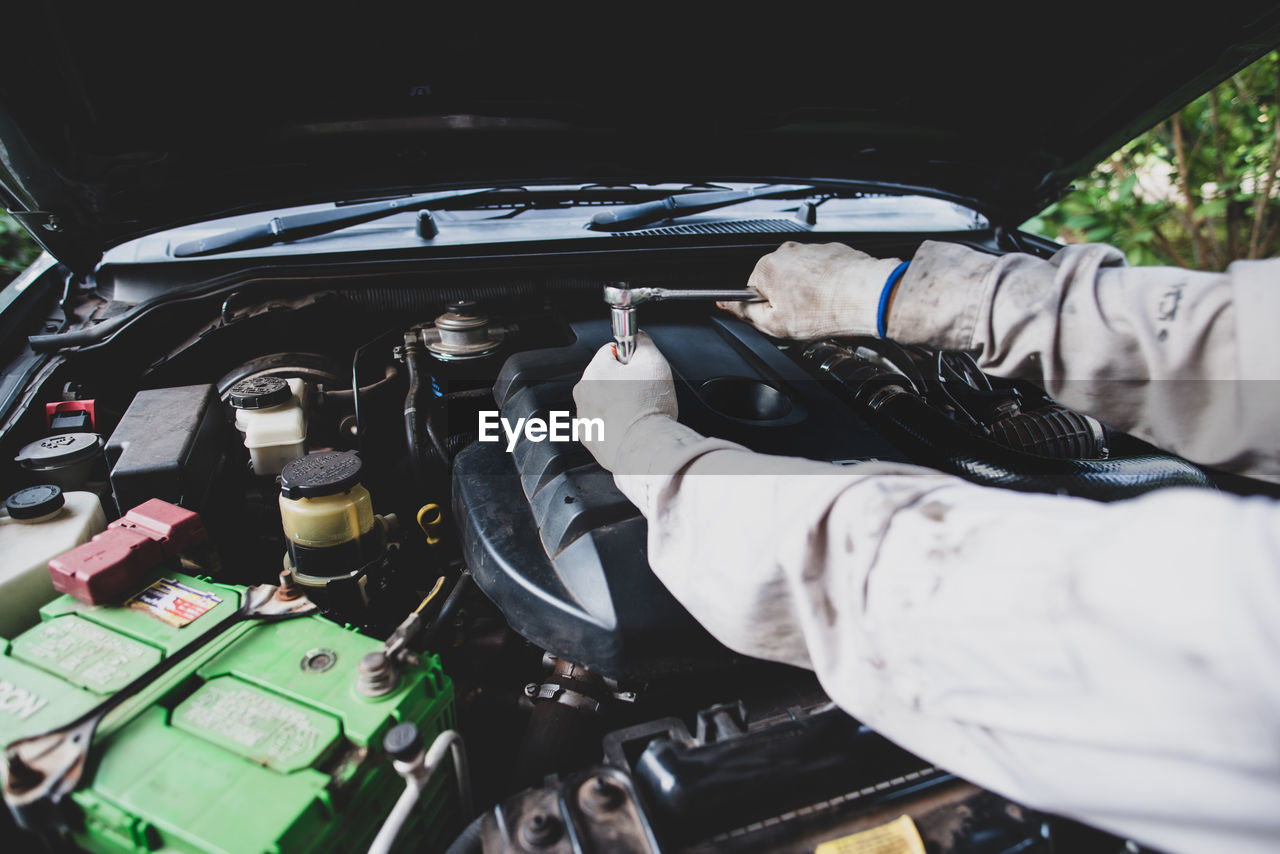 Mechanic repairing car engine in garage