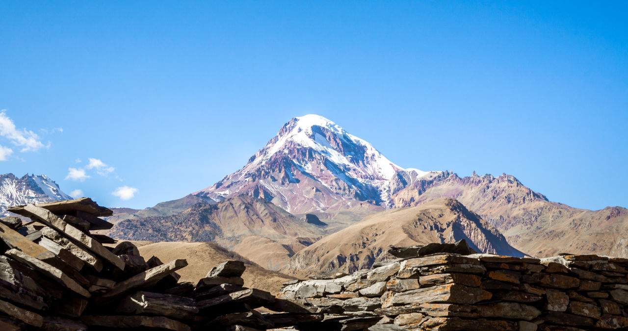 Scenic view of snowcapped mountains against clear blue sky