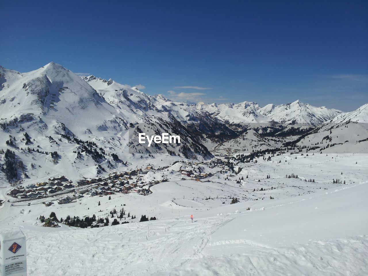 Scenic view of snow covered mountains against clear blue sky