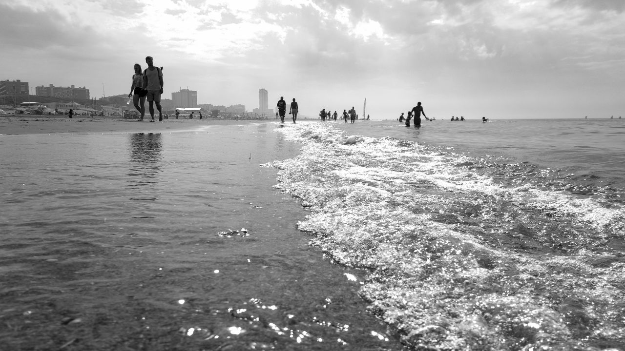 People on beach against sky