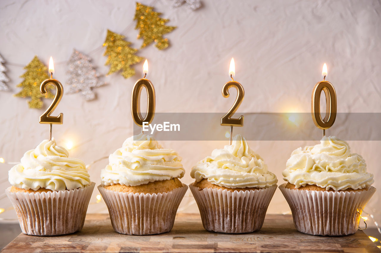 Close-up of lit candles on cupcakes over table