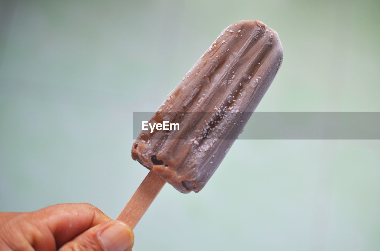 Close-up of hand holding ice cream stick