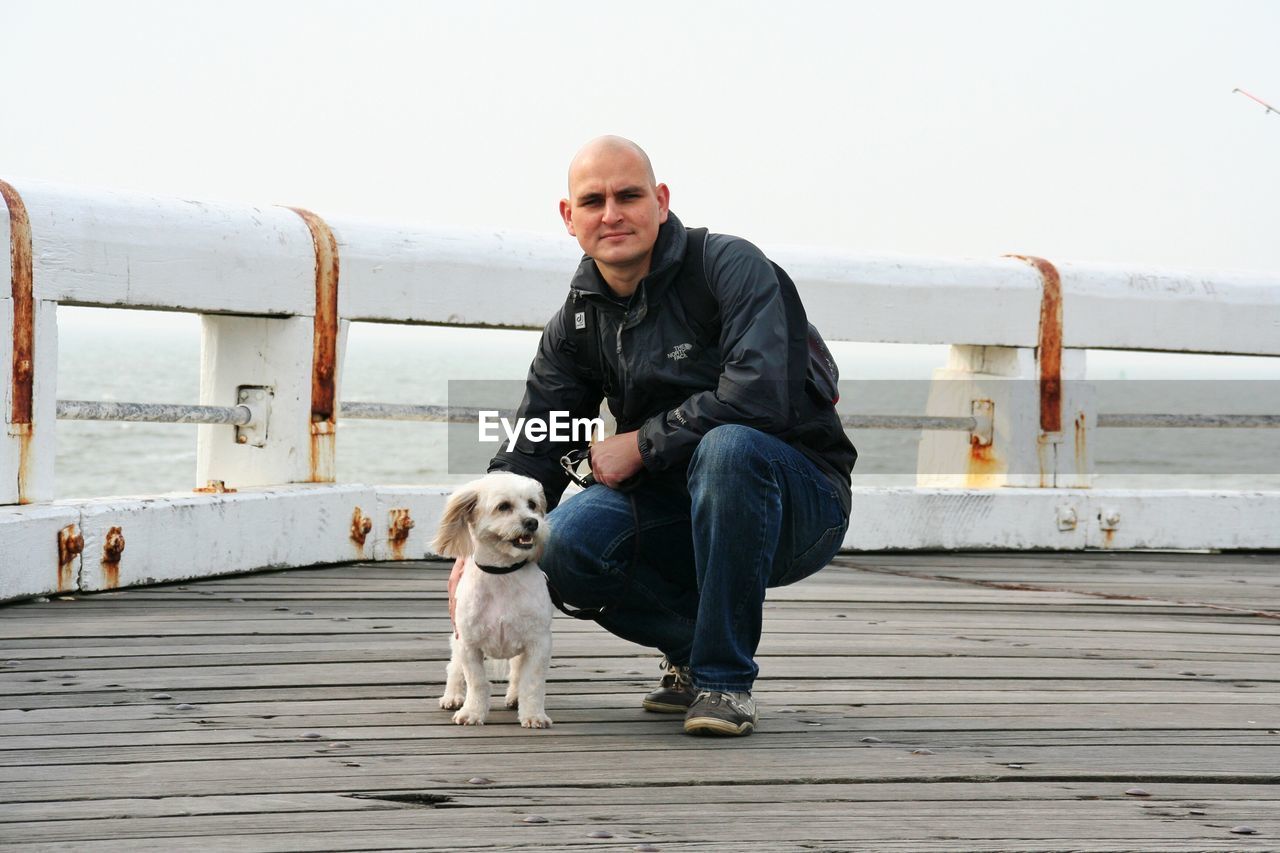 Portrait of a mid adult man with dog outdoors