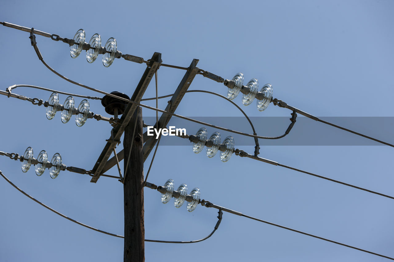 Low angle view of electricity pylon against clear sky