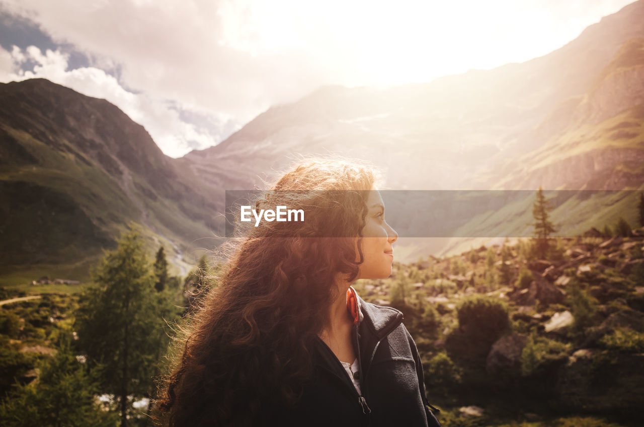 Young woman standing against mountains