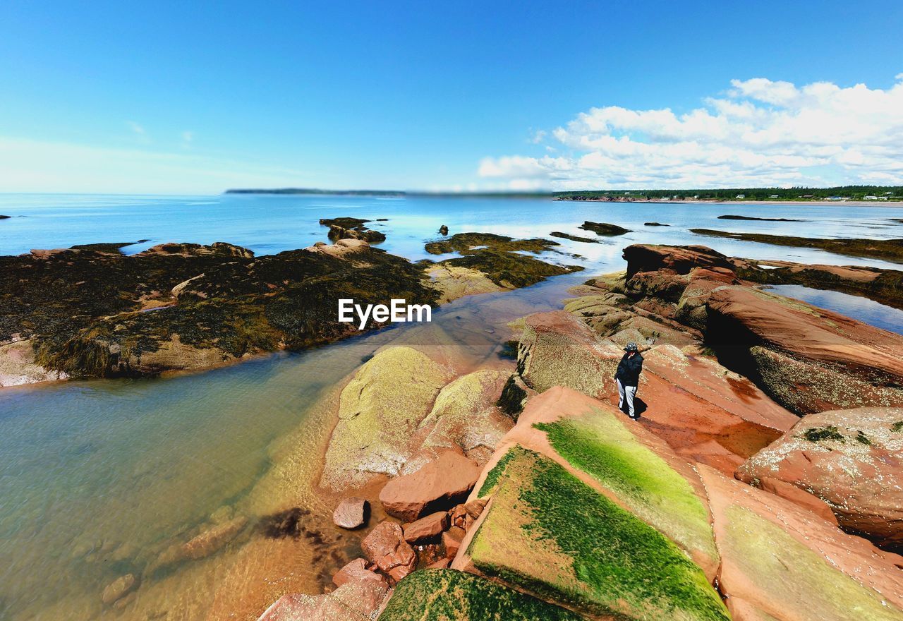 Rocks at sea under blue sky