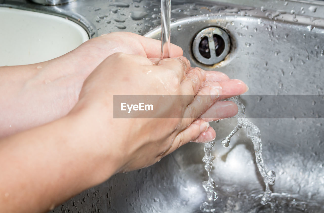 Cropped image of woman washing hands in sink