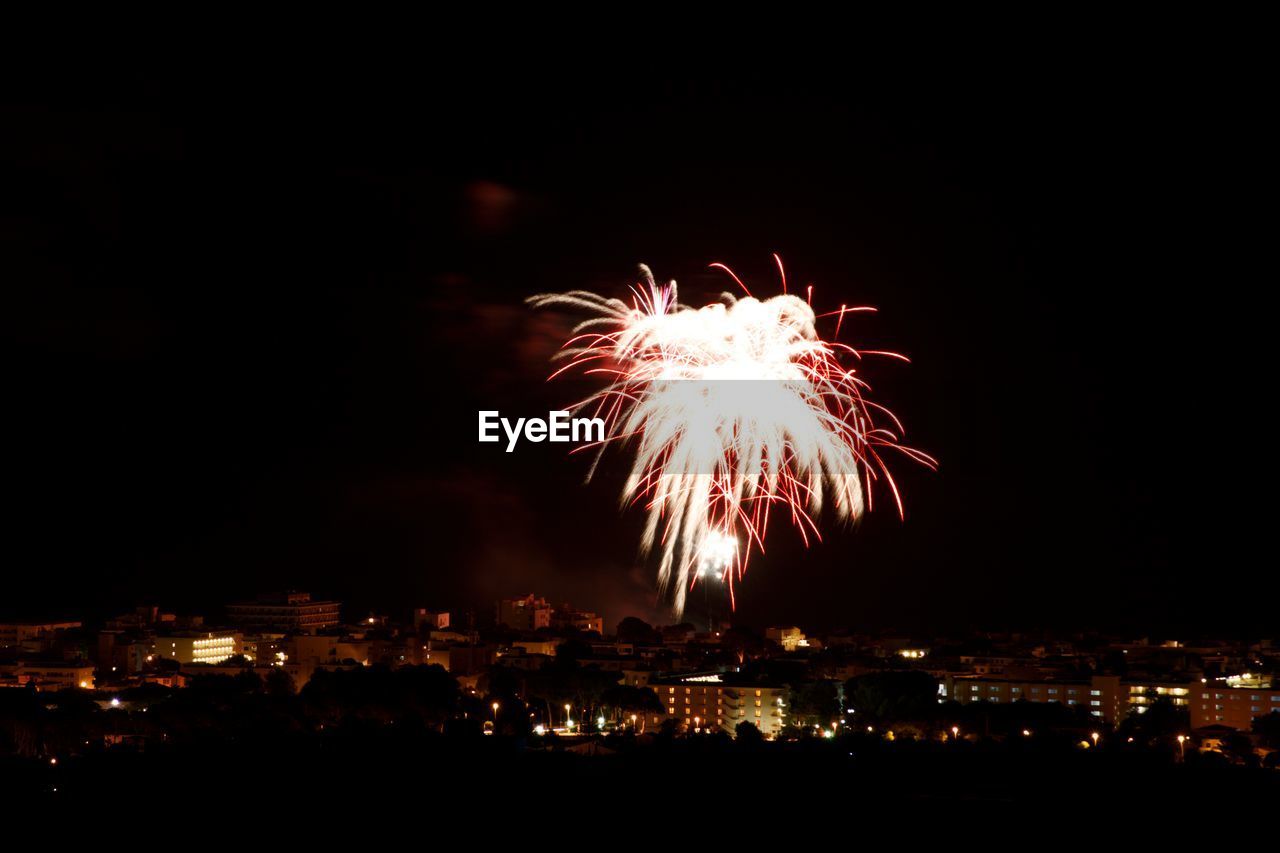 LOW ANGLE VIEW OF FIREWORK DISPLAY AT NIGHT