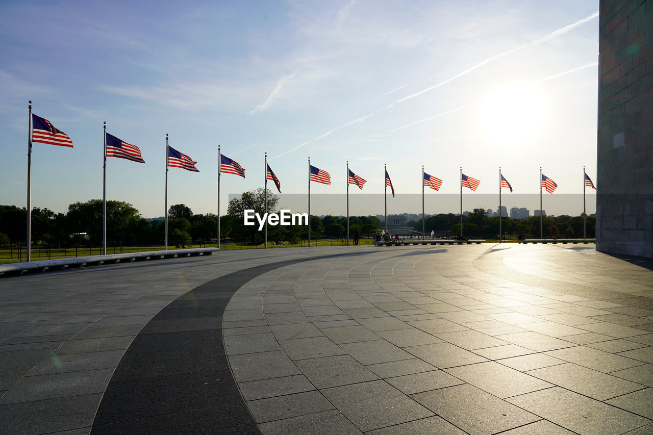 Alignment of american flags in the wind at washington monument during summer sunset 