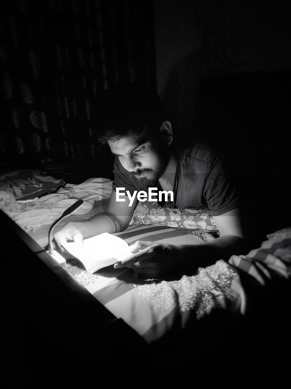 Man reading book on bed