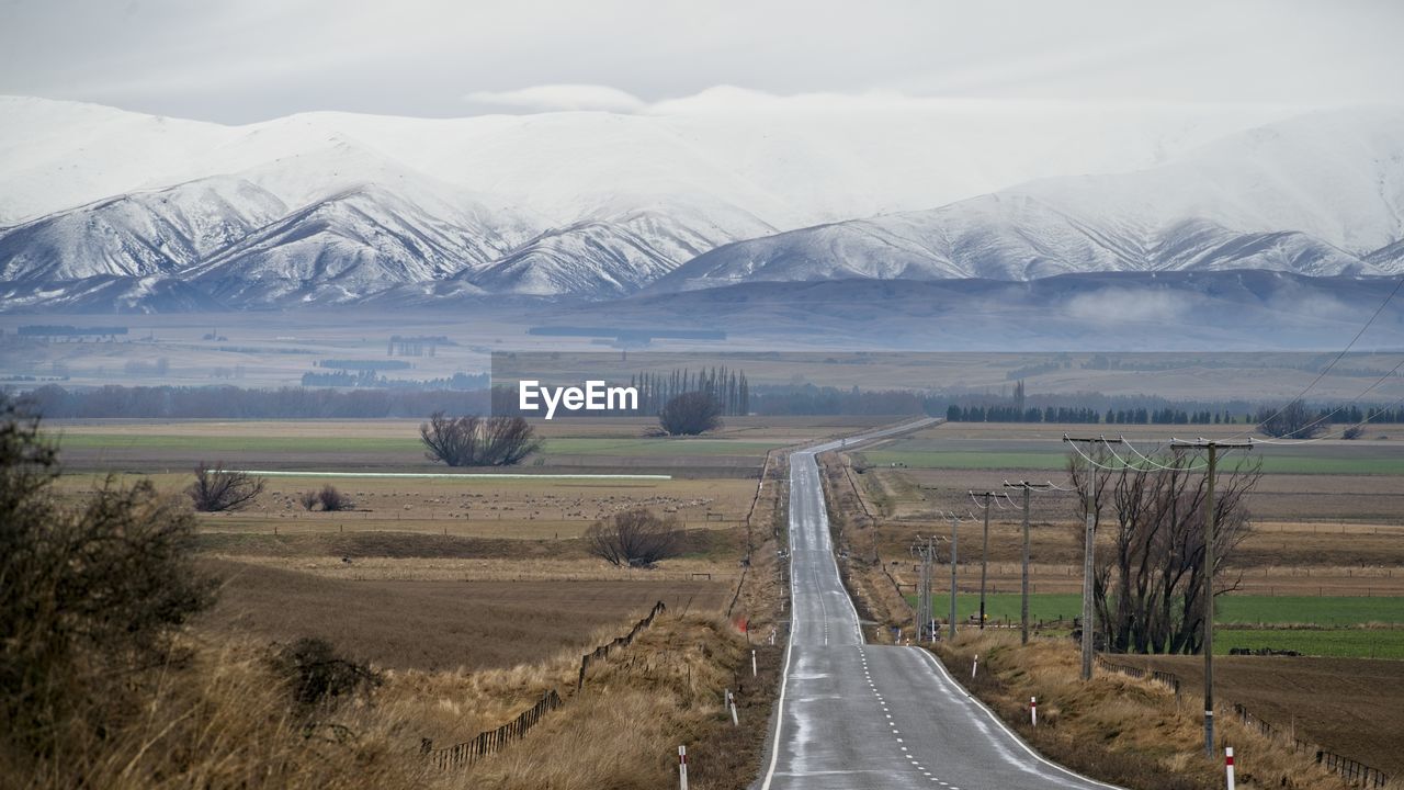 SCENIC VIEW OF ROAD BY MOUNTAINS AGAINST SKY