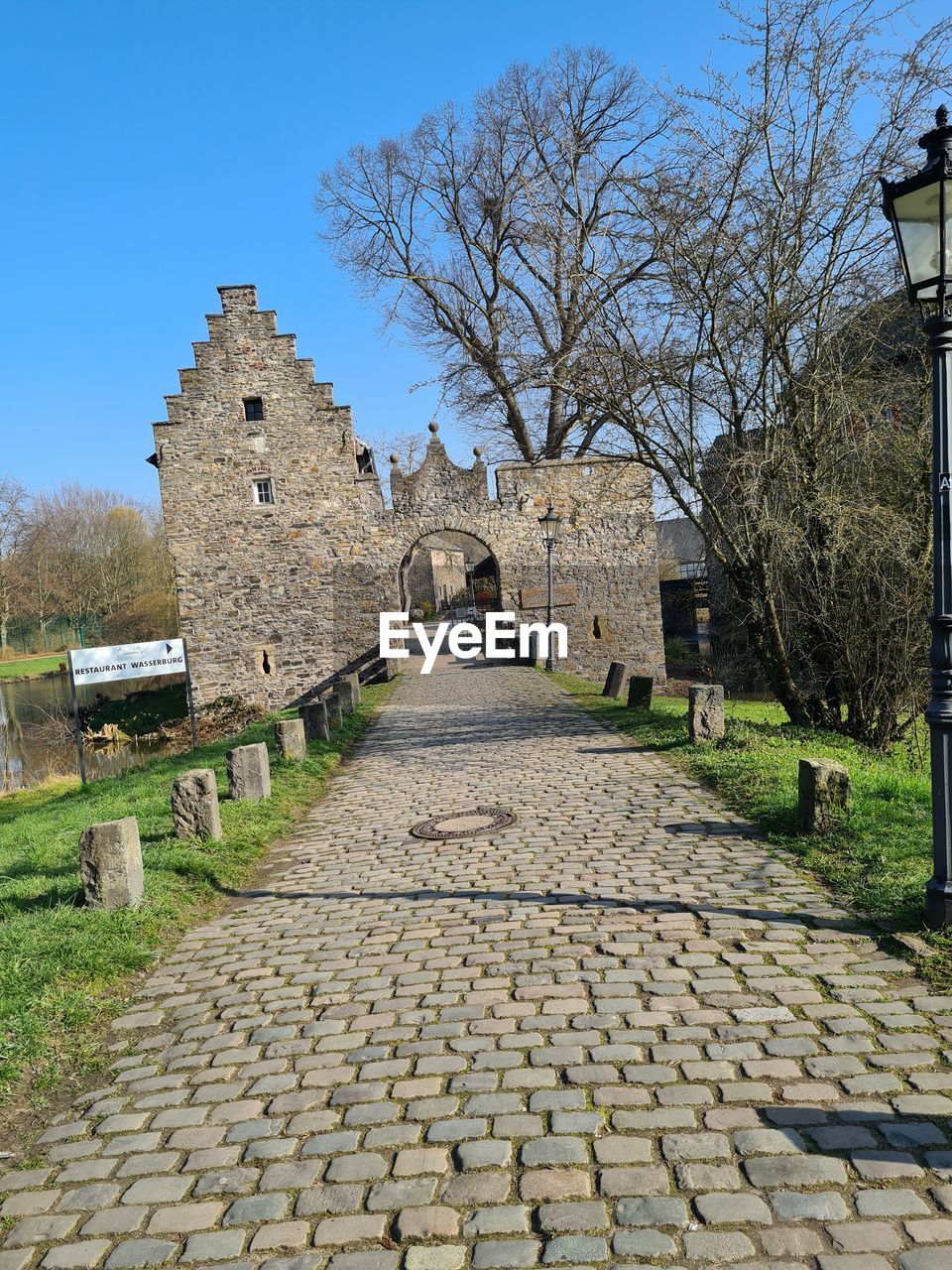 FOOTPATH AMIDST OLD BUILDINGS AGAINST SKY