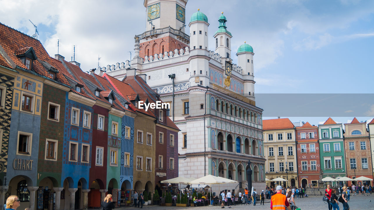 People on street against buildings in town