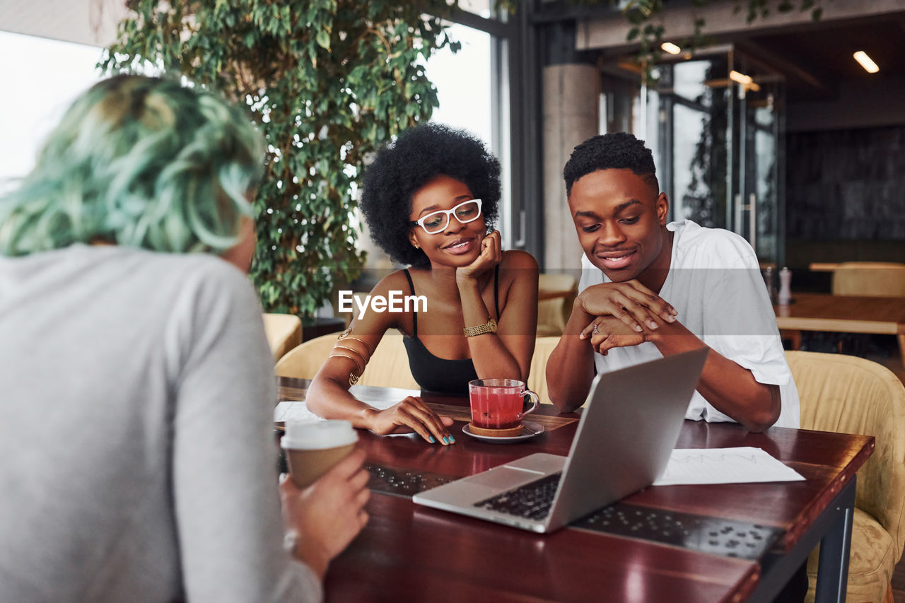 Group of multi ethnic people with alternative girl with green hair is working together