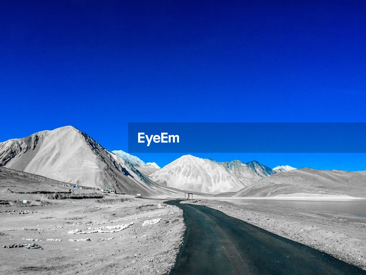 Scenic view of snowcapped mountains against clear blue sky
