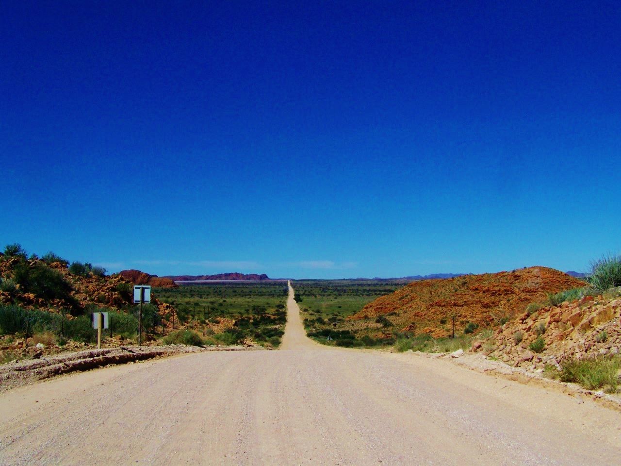 Road amidst landscape against clear blue sky