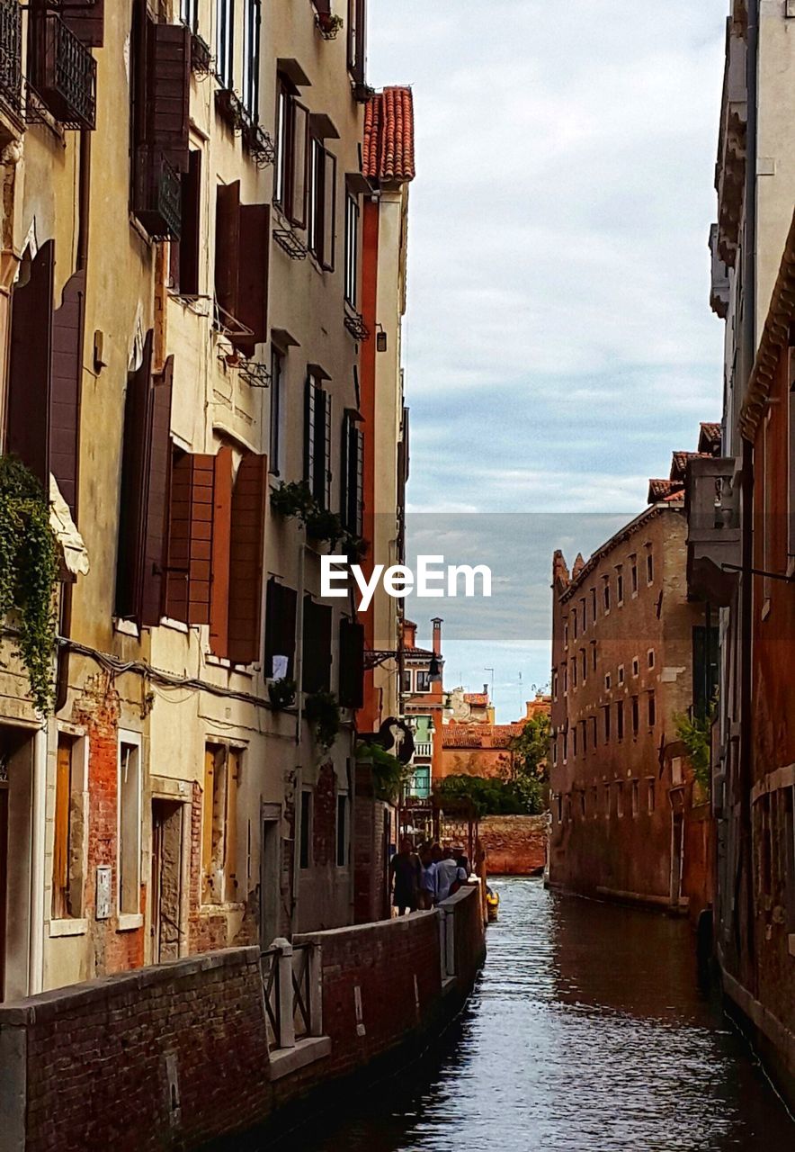VIEW OF CANAL AMIDST BUILDINGS IN CITY