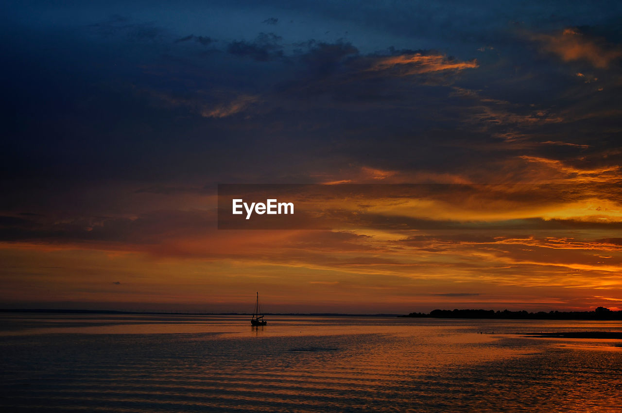 Scenic view of sea against orange sky