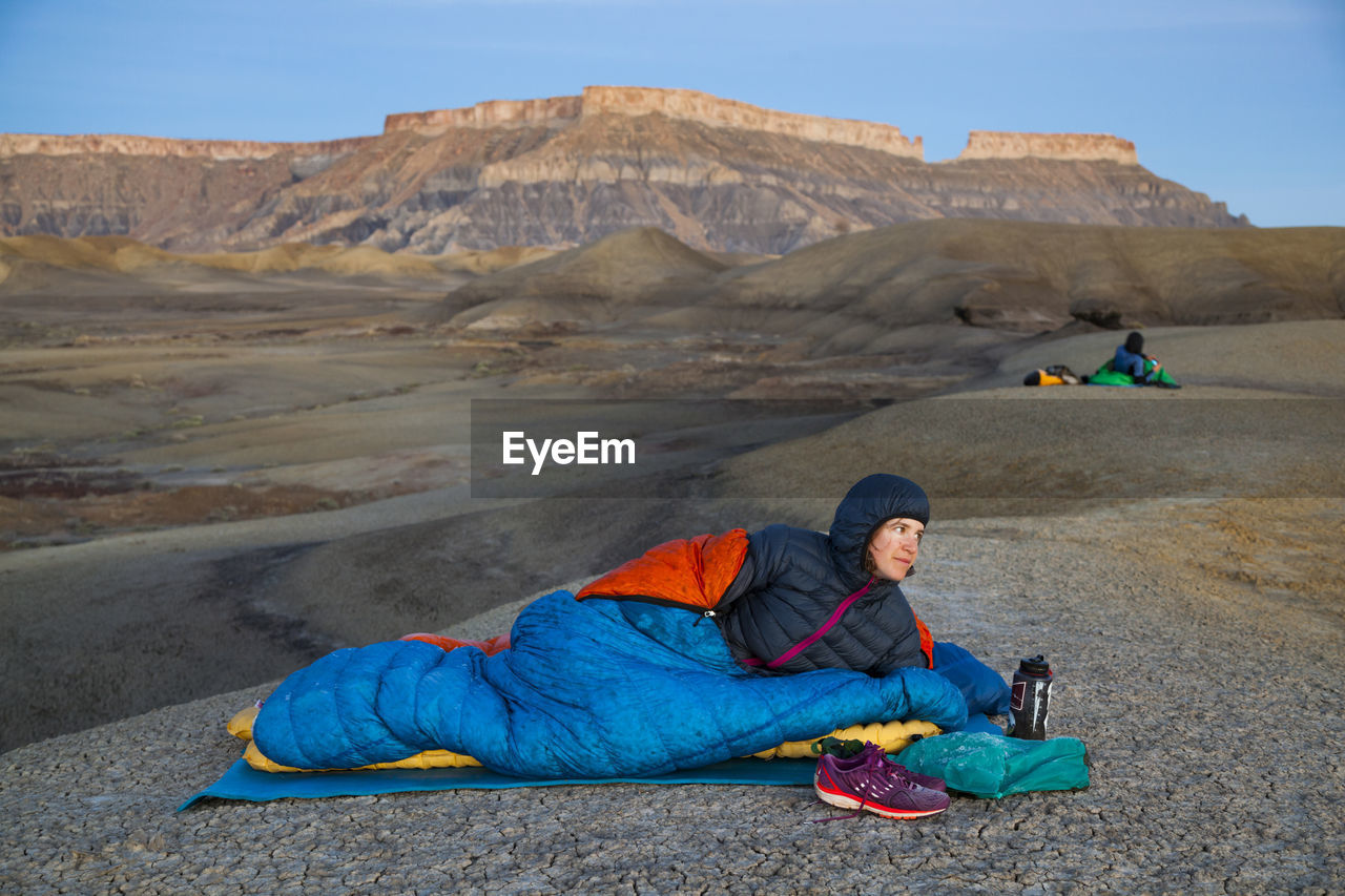 People watch sunrise from camp in factory butte badlands, utah