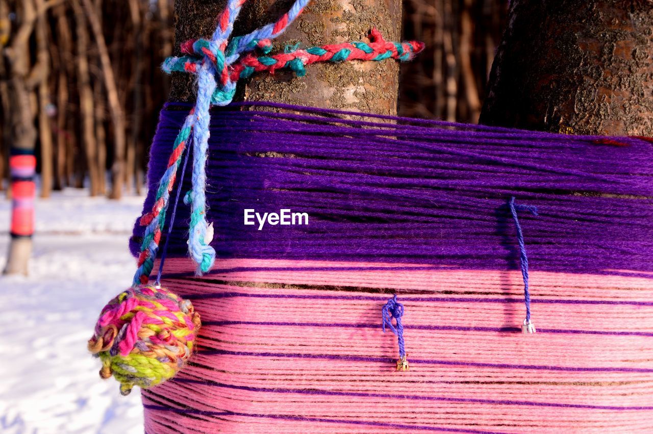 Close-up of multi colored decorations hanging on wood