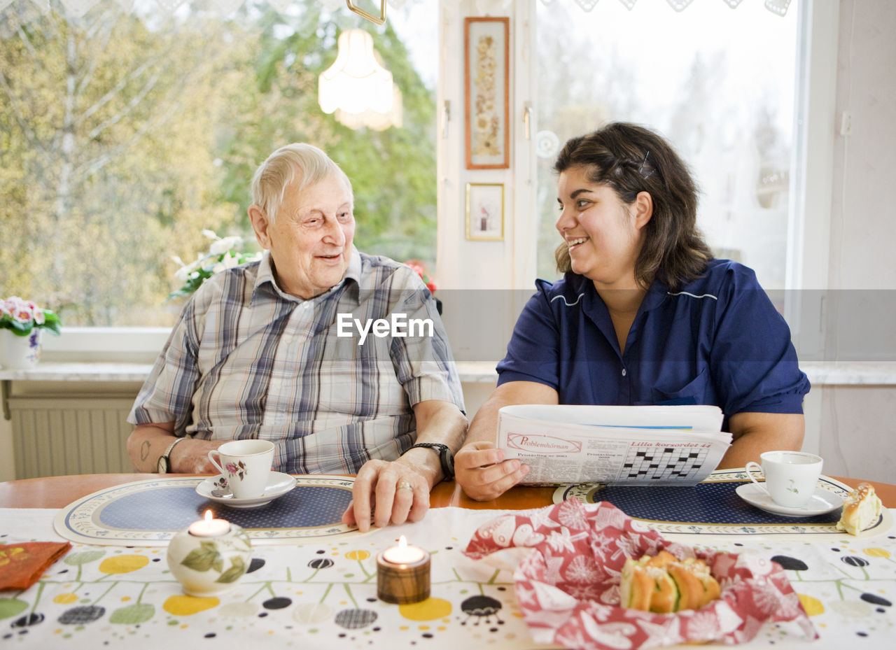 Nurse with senior man at table, sweden