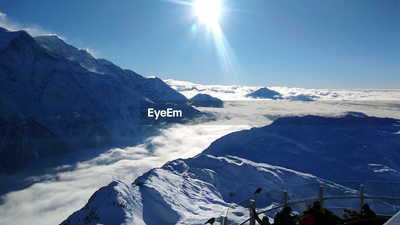 SCENIC VIEW OF SNOWCAPPED MOUNTAINS AGAINST BRIGHT SKY