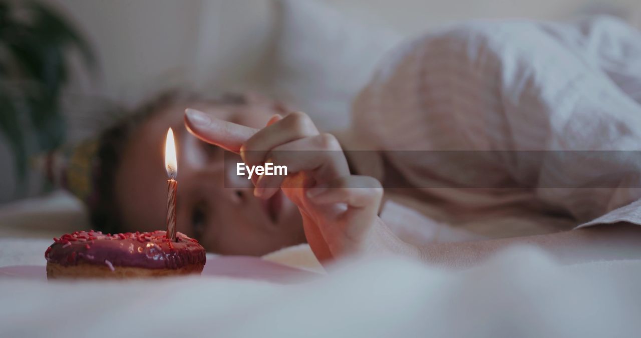 Close-up of woman lying on bed at home