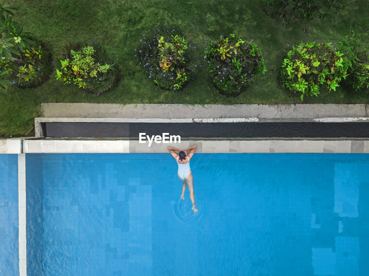 Aerial view of attractive woman floating over water at resort