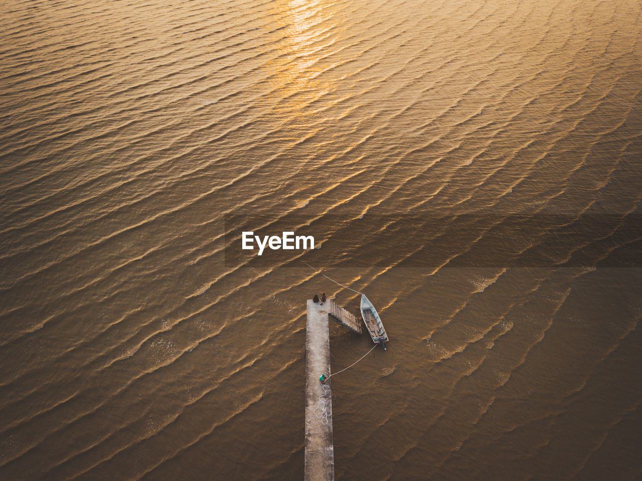 High angle view of fishing boat moored at sea during sunset