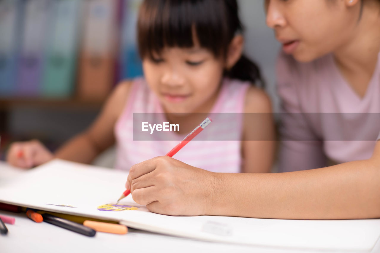 close-up of boy drawing on book