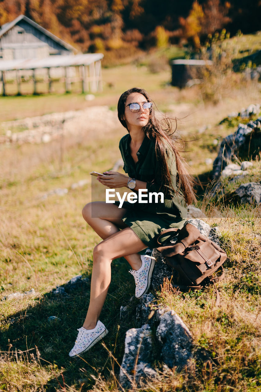 Full length of woman sitting on rock