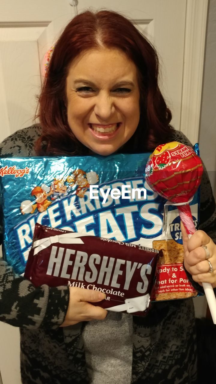 PORTRAIT OF A SMILING YOUNG WOMAN AT HOME