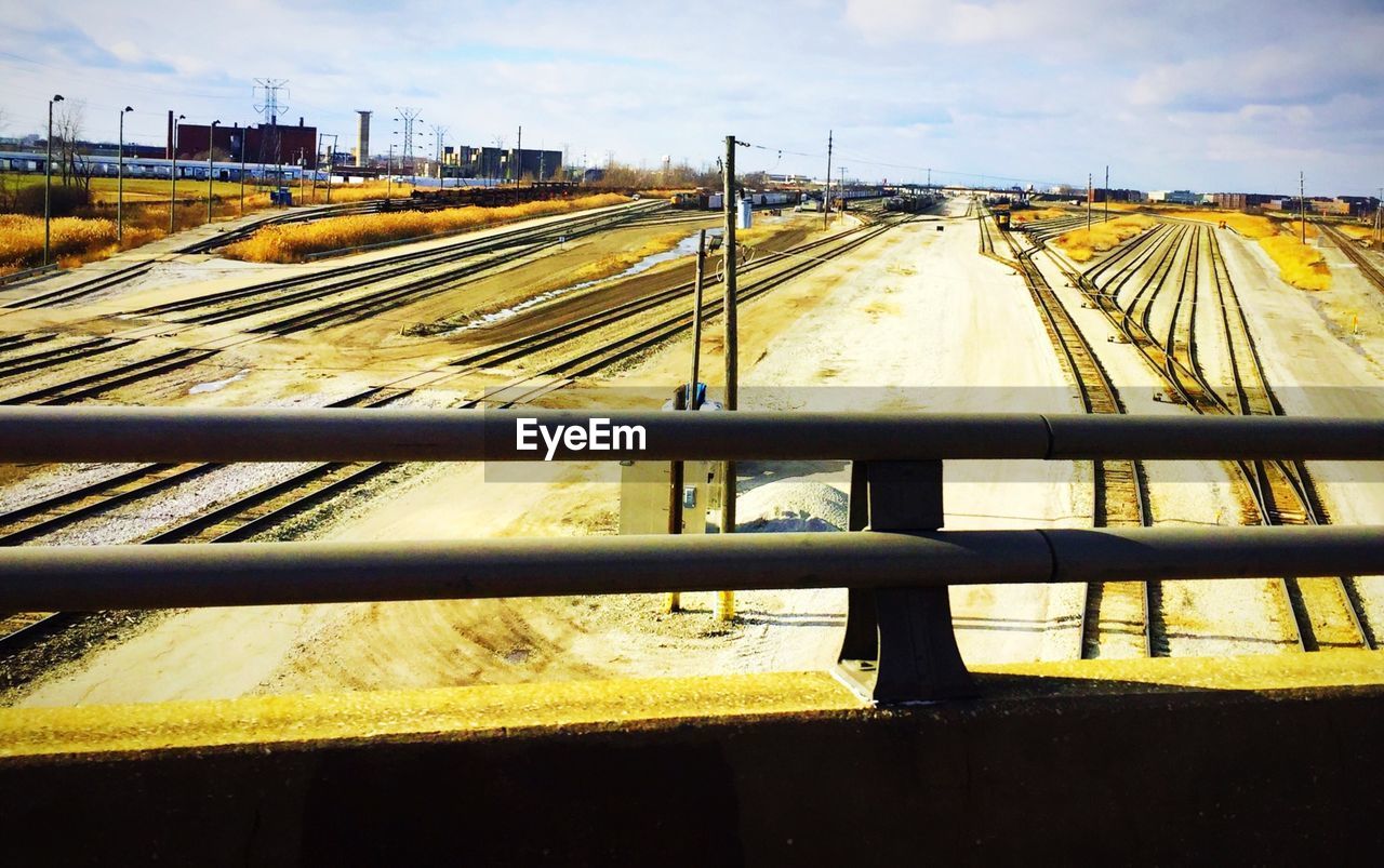 High angle view of railroad tracks on field against sky