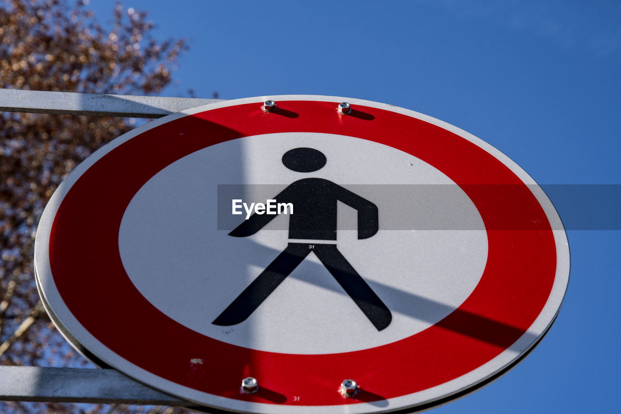 CLOSE-UP OF ROAD SIGN AGAINST BLUE SKY