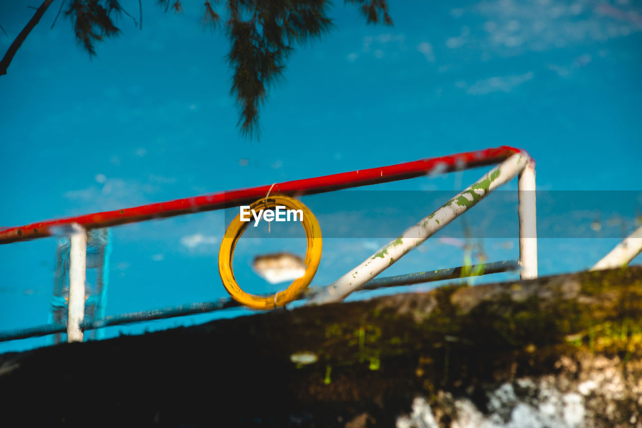 Low angle view of railing against blue sky