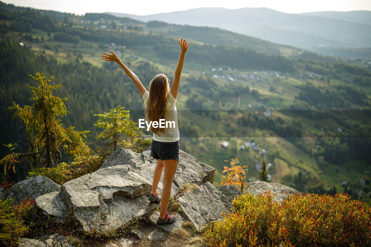 Full length rear view of woman standing on mountain