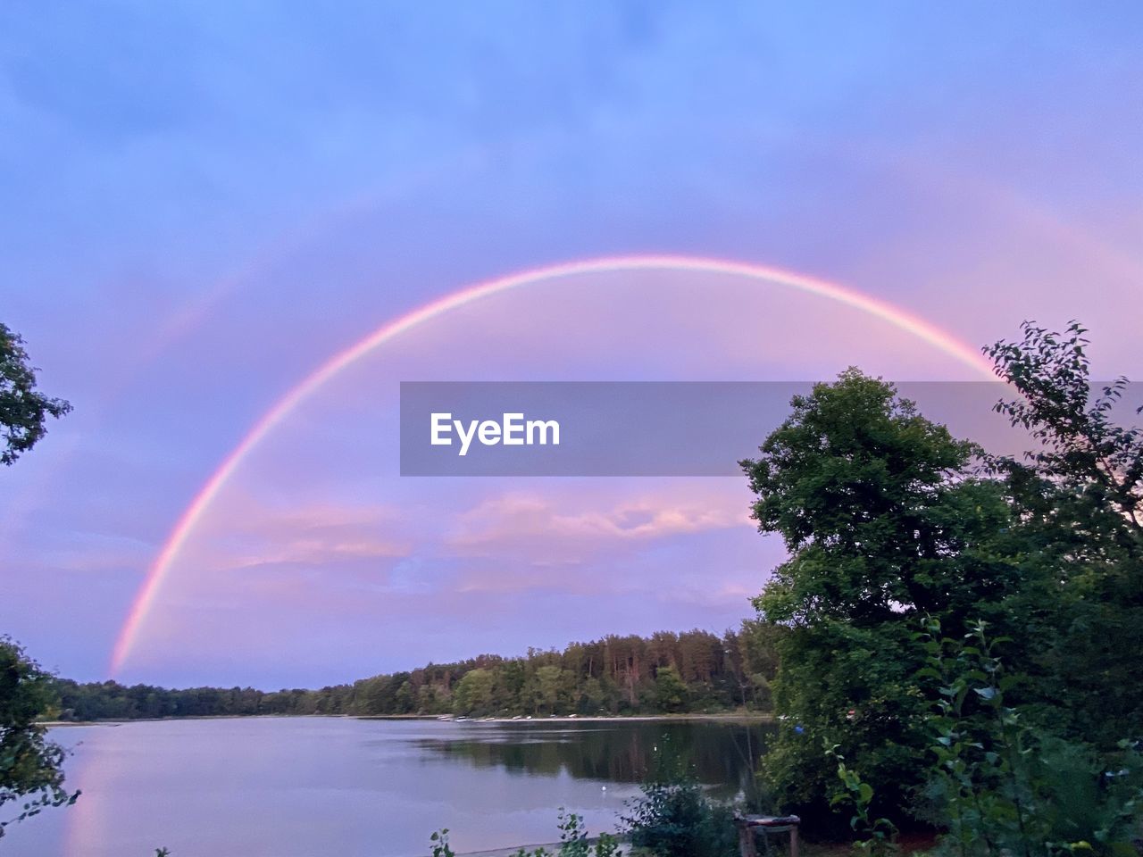 rainbow, tree, sky, beauty in nature, plant, water, cloud, scenics - nature, nature, tranquility, tranquil scene, multi colored, reflection, environment, no people, lake, landscape, idyllic, outdoors, sunset, dusk, non-urban scene, blue, double rainbow, land, forest, sunlight, natural phenomenon, day
