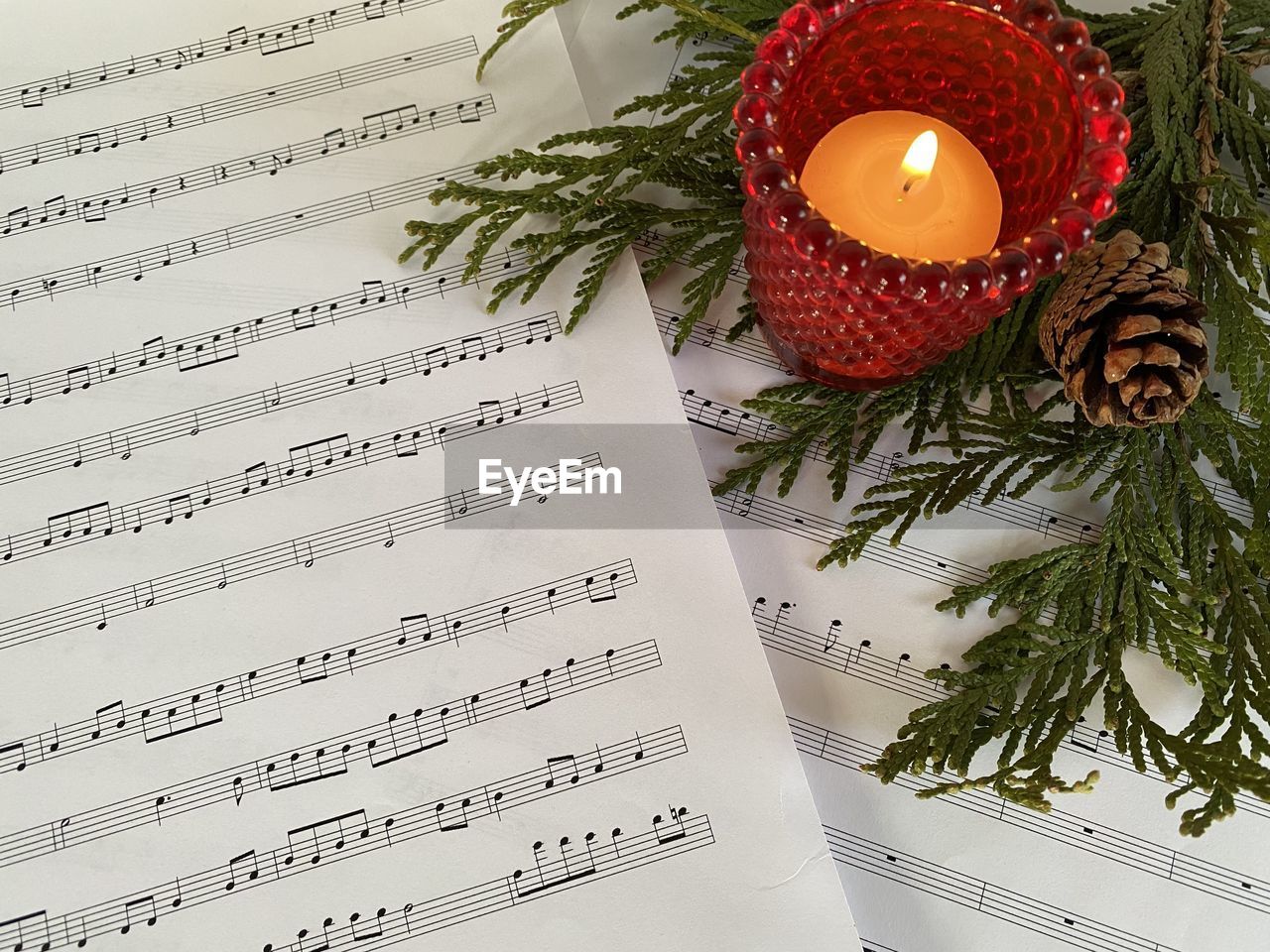 Sheet music with evergreens and candle