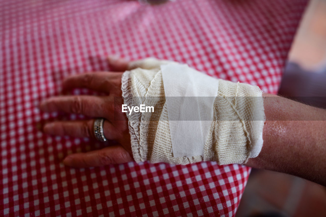 Close-up of woman hand with bandage on table
