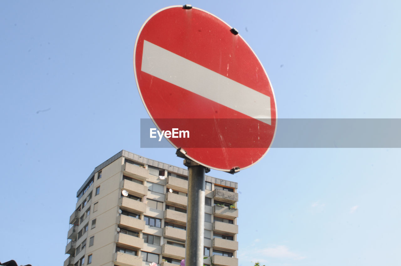 Skyscraper in the city, with a no entry traffic sign in front of it