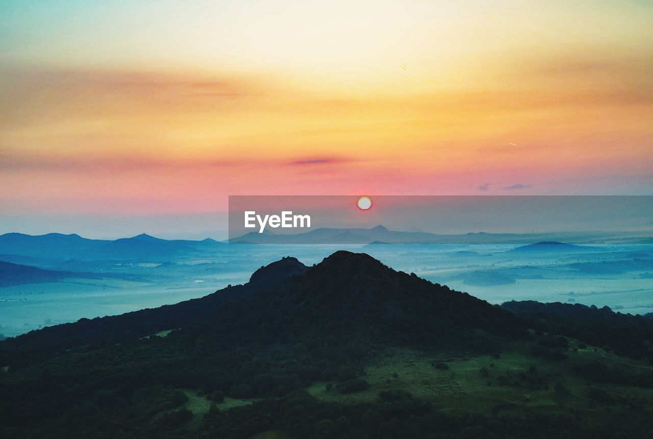 Scenic view of silhouette mountains against sky at sunset