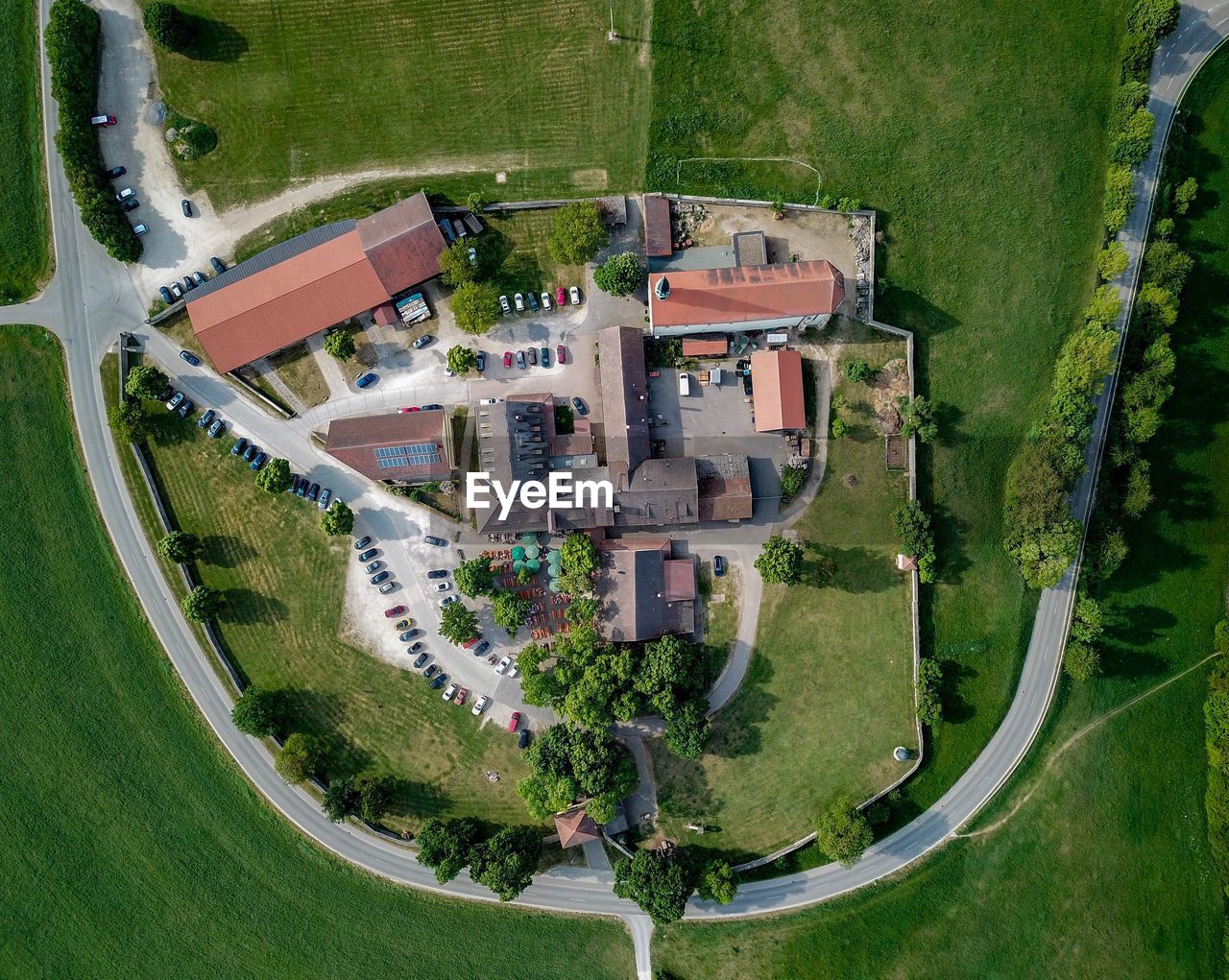 HIGH ANGLE VIEW OF TREES AND BUILDINGS ON FIELD