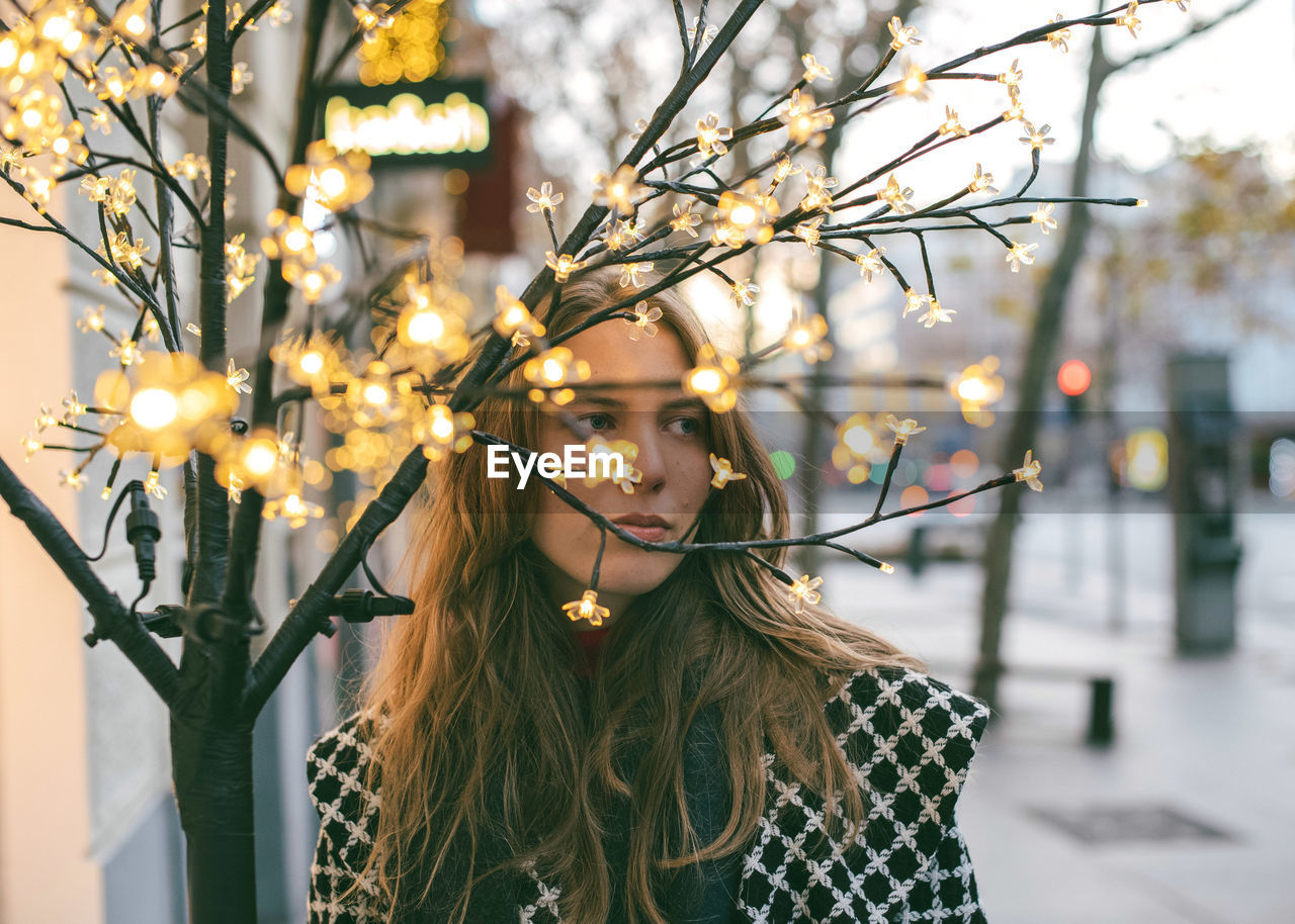 Portrait of a beautiful blonde woman behind some branches.