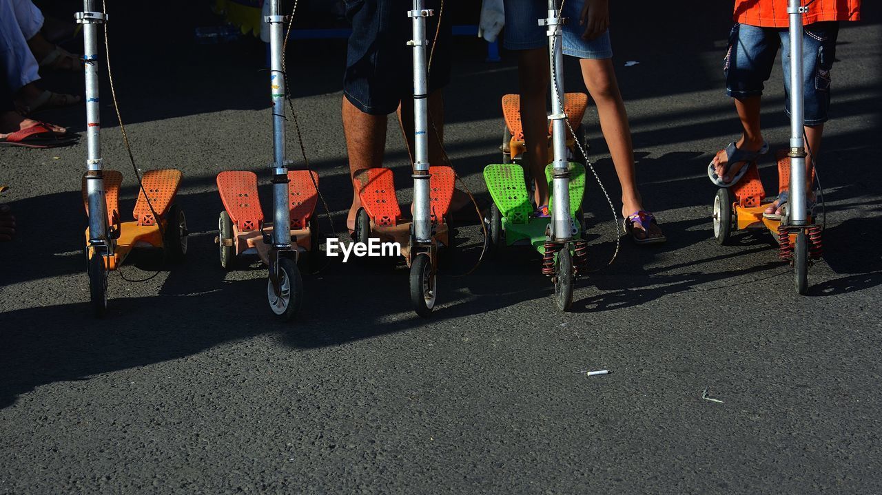 Low section of children with push scooters on road