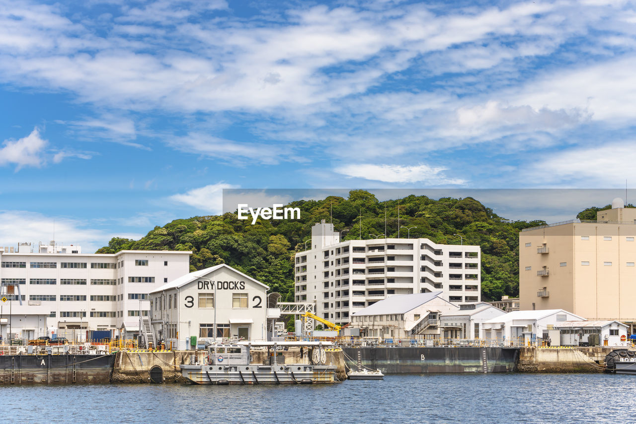 Diving support vessel ds-02 berthed in front of dry docks of the yokosuka naval base.