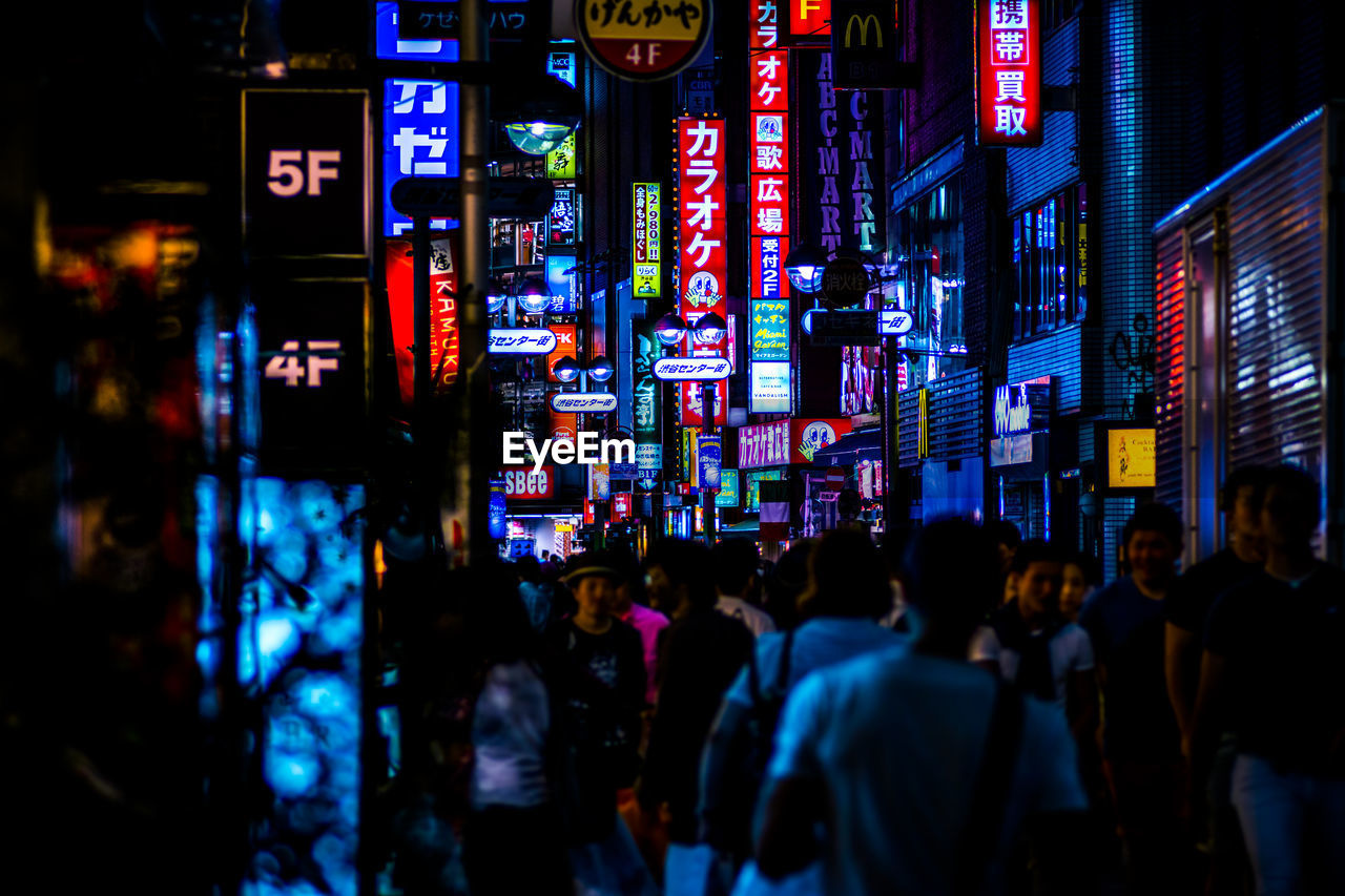 Crowd at illuminated street market during night