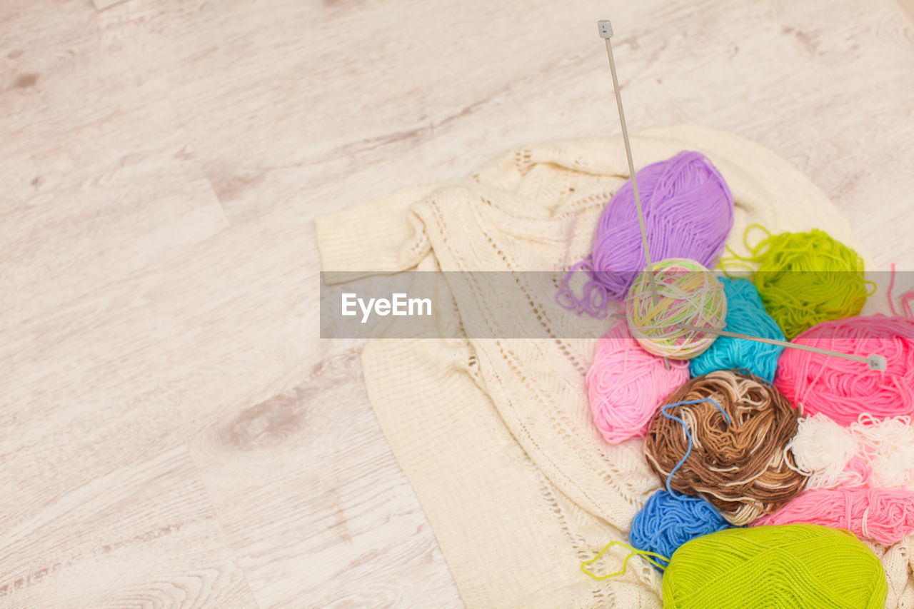 High angle view of colorful wool on wooden table