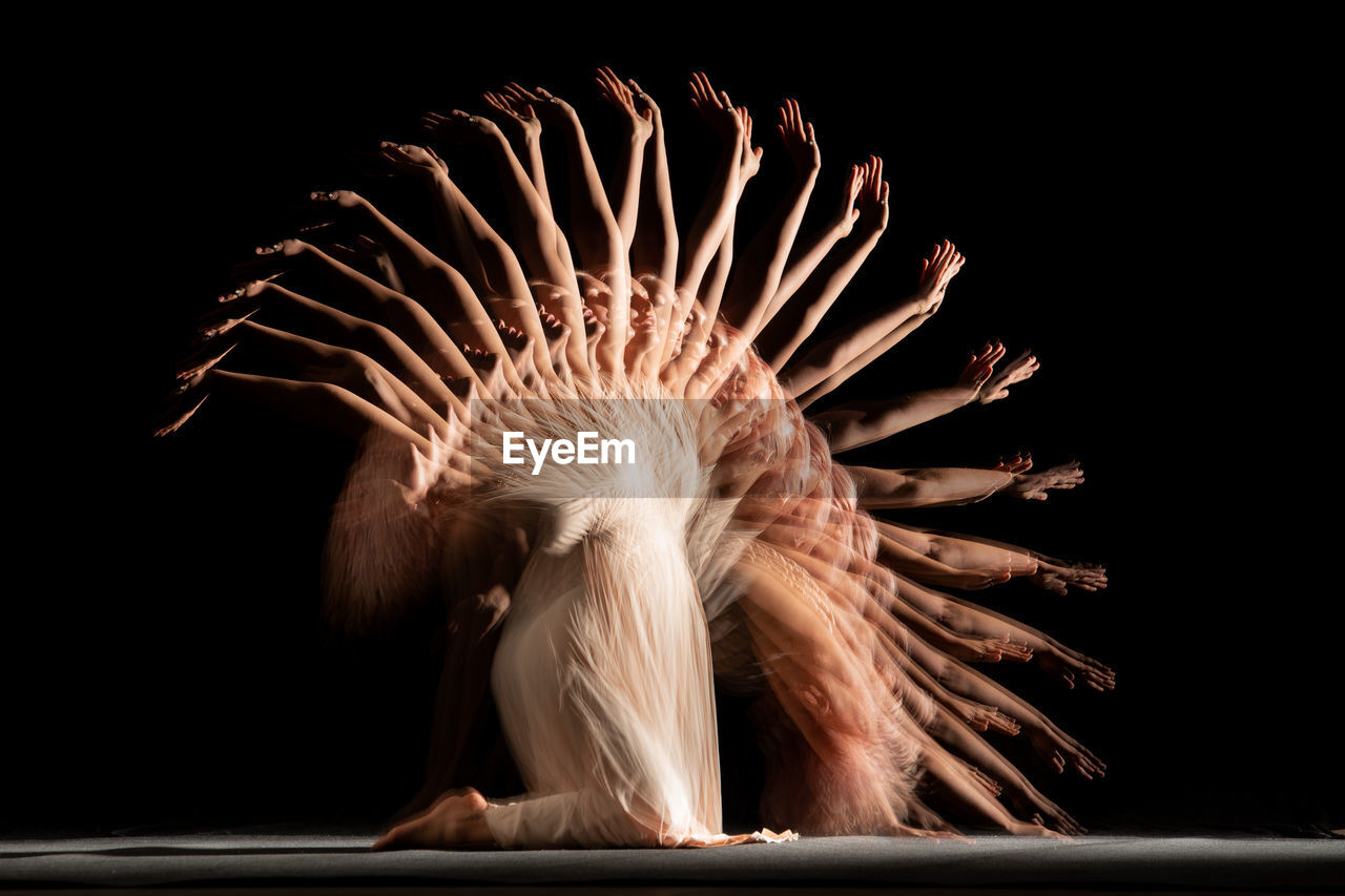 Young woman in front of black background. long exposure with stroboscopic flash